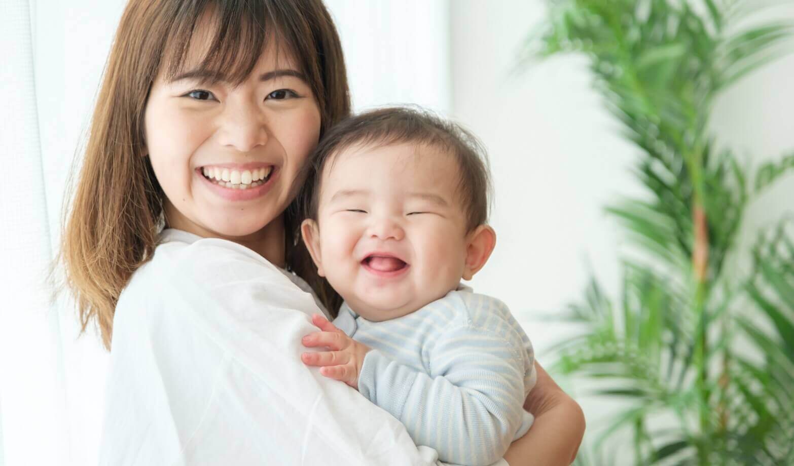 赤ちゃんを抱っこして笑う女性